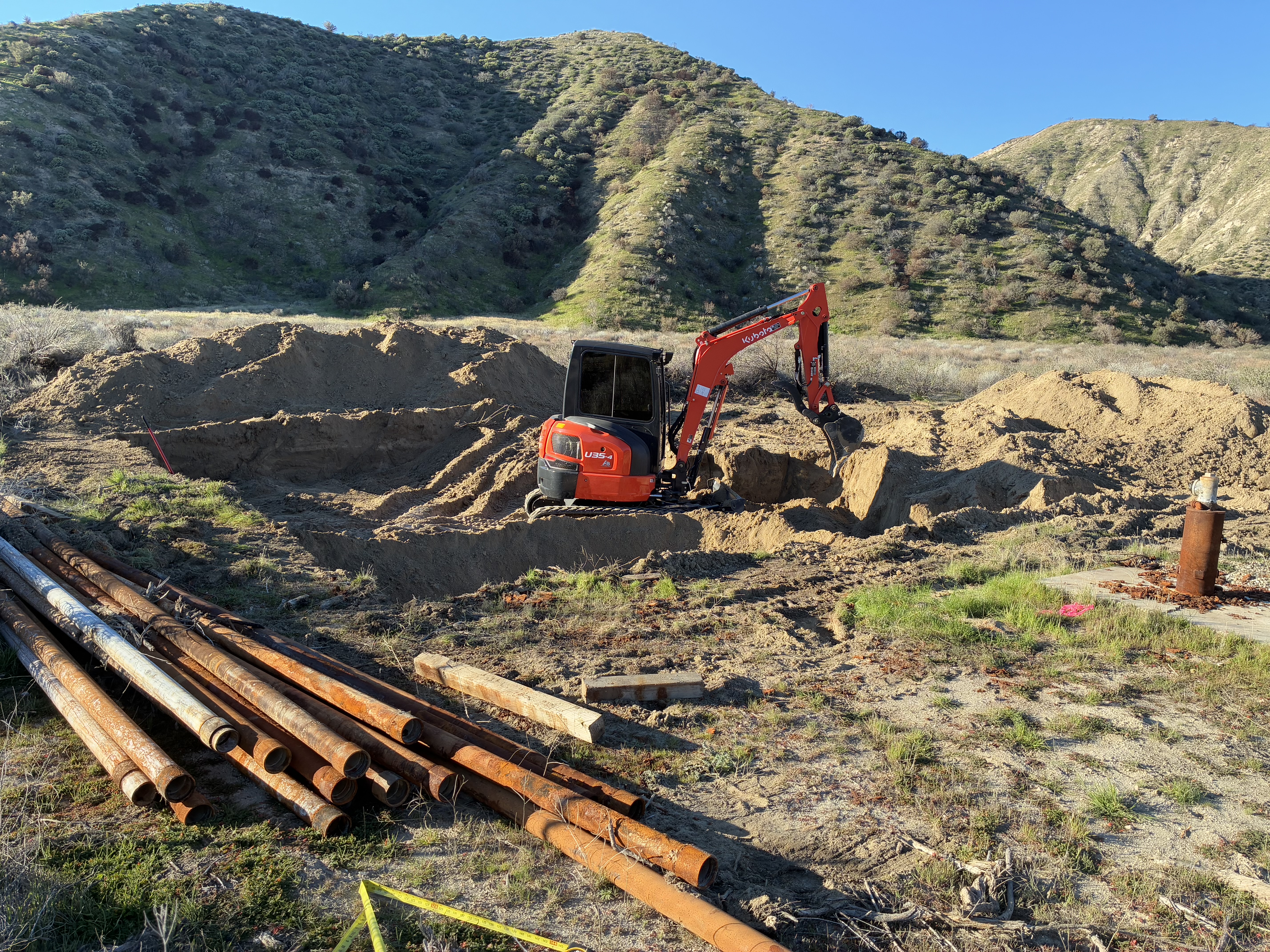 Construction of catchment basins to contain drilling mud during test well drilling.