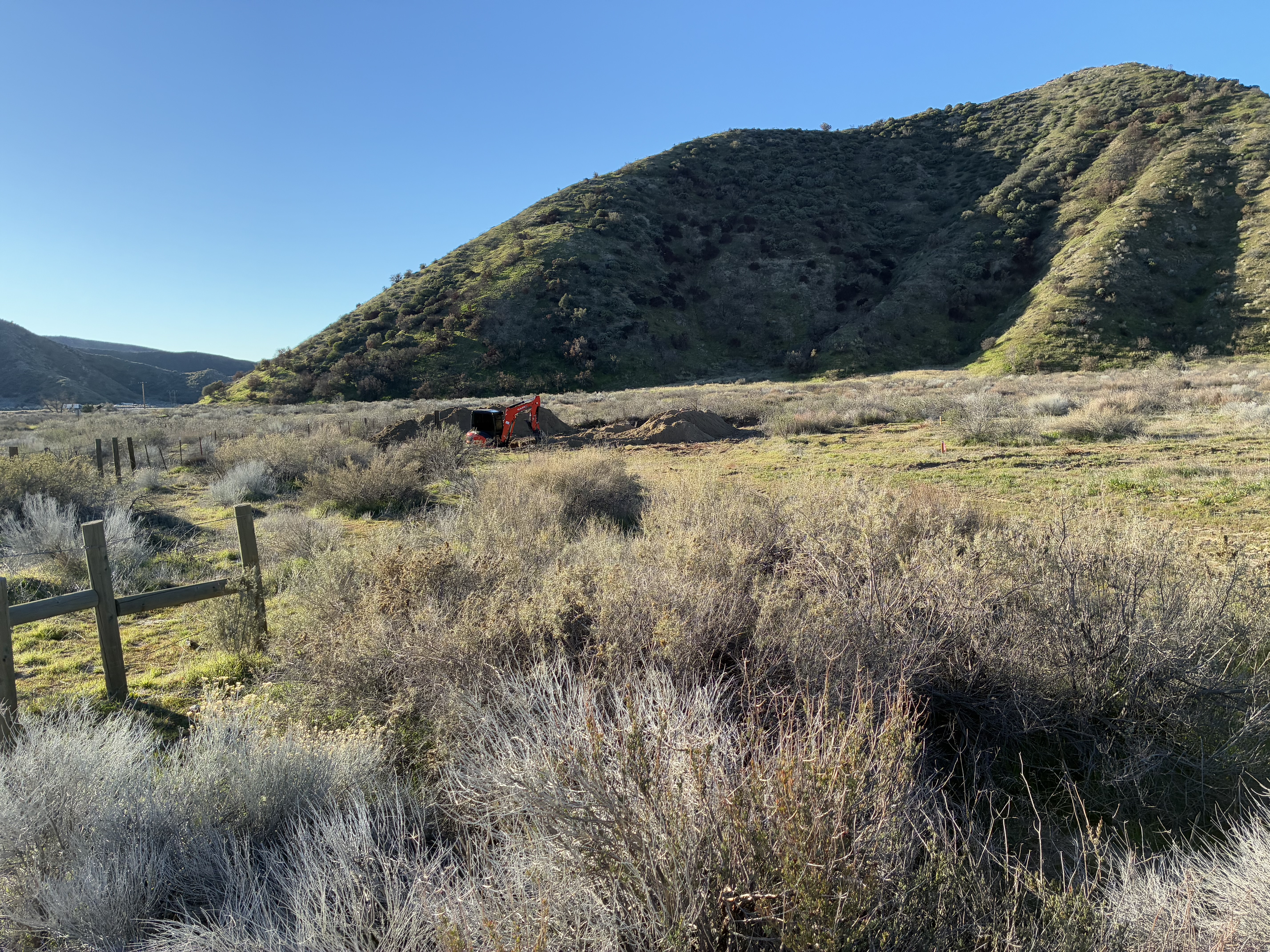 Construction of catchment basins to contain drilling mud during test well drilling.